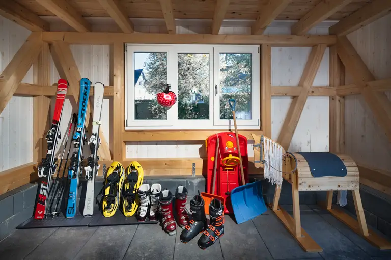 Innenansicht des abschließbaren Abstellraums mit Wintersportgeräten wie Skier und Snowboards in der Ferienwohnung