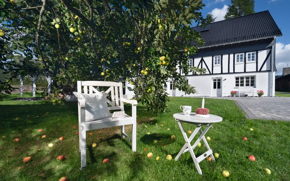 Gartenstuhl und Beistelltisch unter dem Apfelbaum im Obstgarten – Ferienwohnung Sauerland