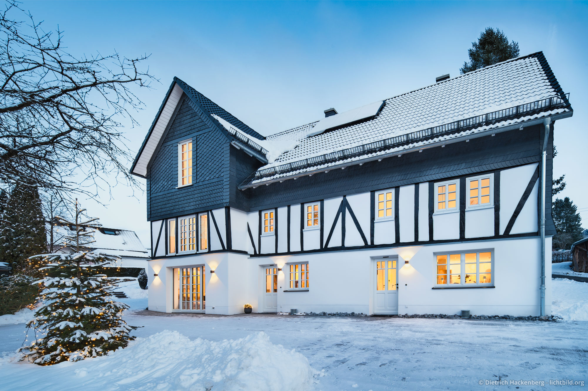 Beleuchtete Fenster des Ferienhauses in der winterlichen blauen Stunde. Ferienwohnung im Fachwerkhaus Eiben, Kirchhundem-Benolpe