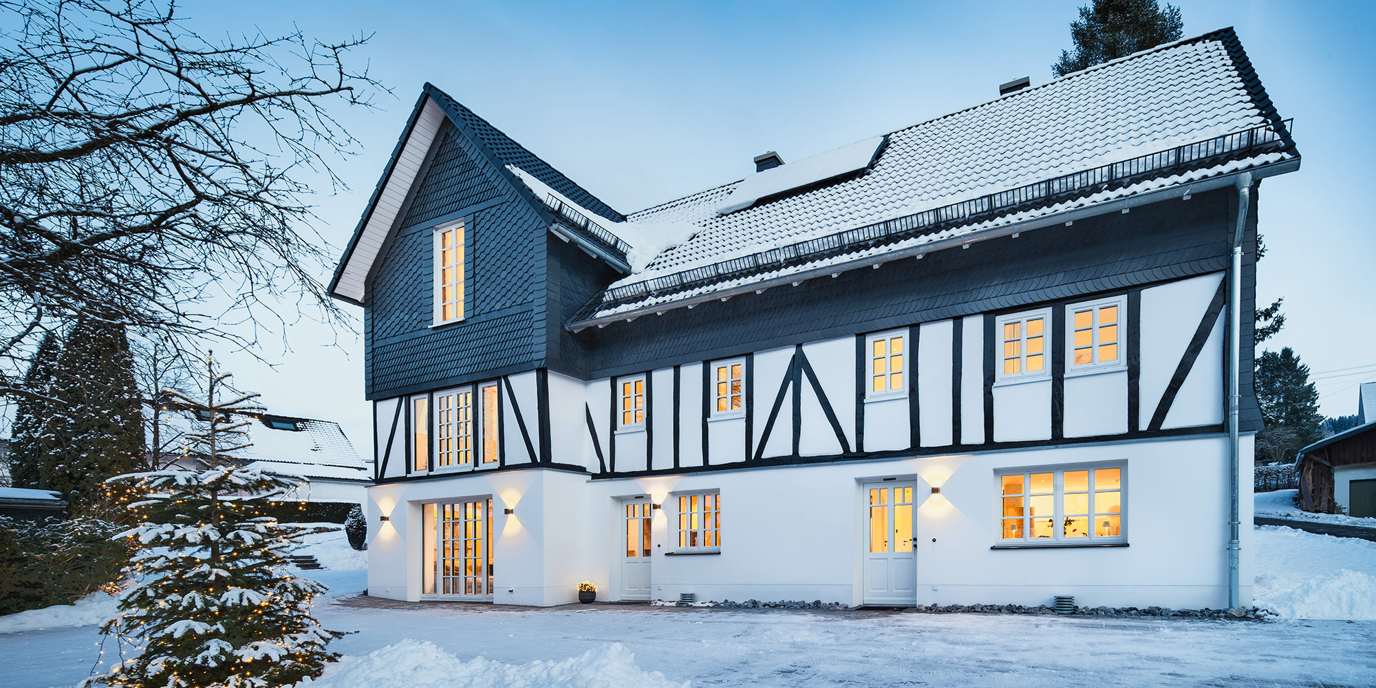 Front des Fachwerkhauses im Schnee mit beleuchteten Fenstern - Ferienhaus Fachwerkhaus Eiben, Benolpe