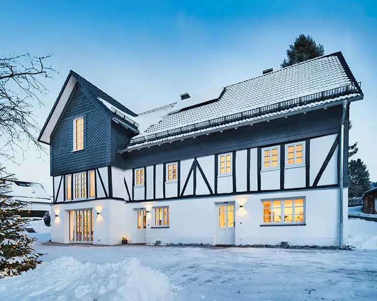 haus-eiben-fassade-front-blaue-stunde-b-768 Beleuchtete Fenster des Ferienhauses in der winterlichen blauen Stunde. Sauerland Ferienwohnung - Fachwerkhaus Eiben, Benolpe