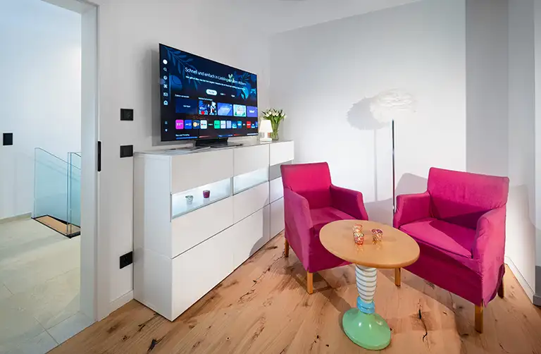 Zwei Sessel mit Bistrotisch und großem Fernseher in Schlafzimmer 2