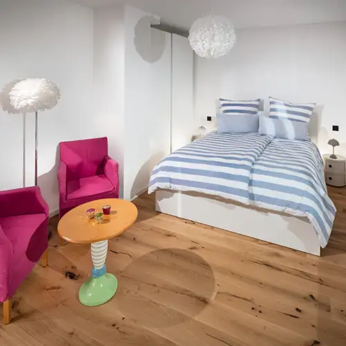 Blick ins Schlafzimmer zwei mit zwei Sesseln und einem kleinen Bistrotisch. Sauerland Ferienwohnung - Fachwerkhaus Eiben, Benolpe