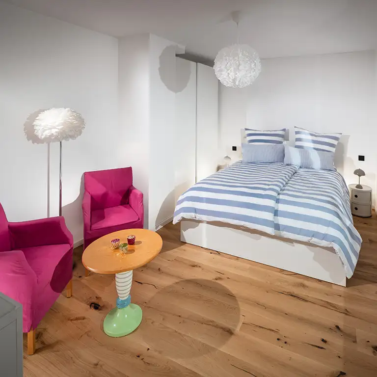 Blick ins Schlafzimmer zwei mit zwei Sesseln und einem kleinen Bistrotisch. Sauerland Ferienwohnung - Fachwerkhaus Eiben, Benolpe