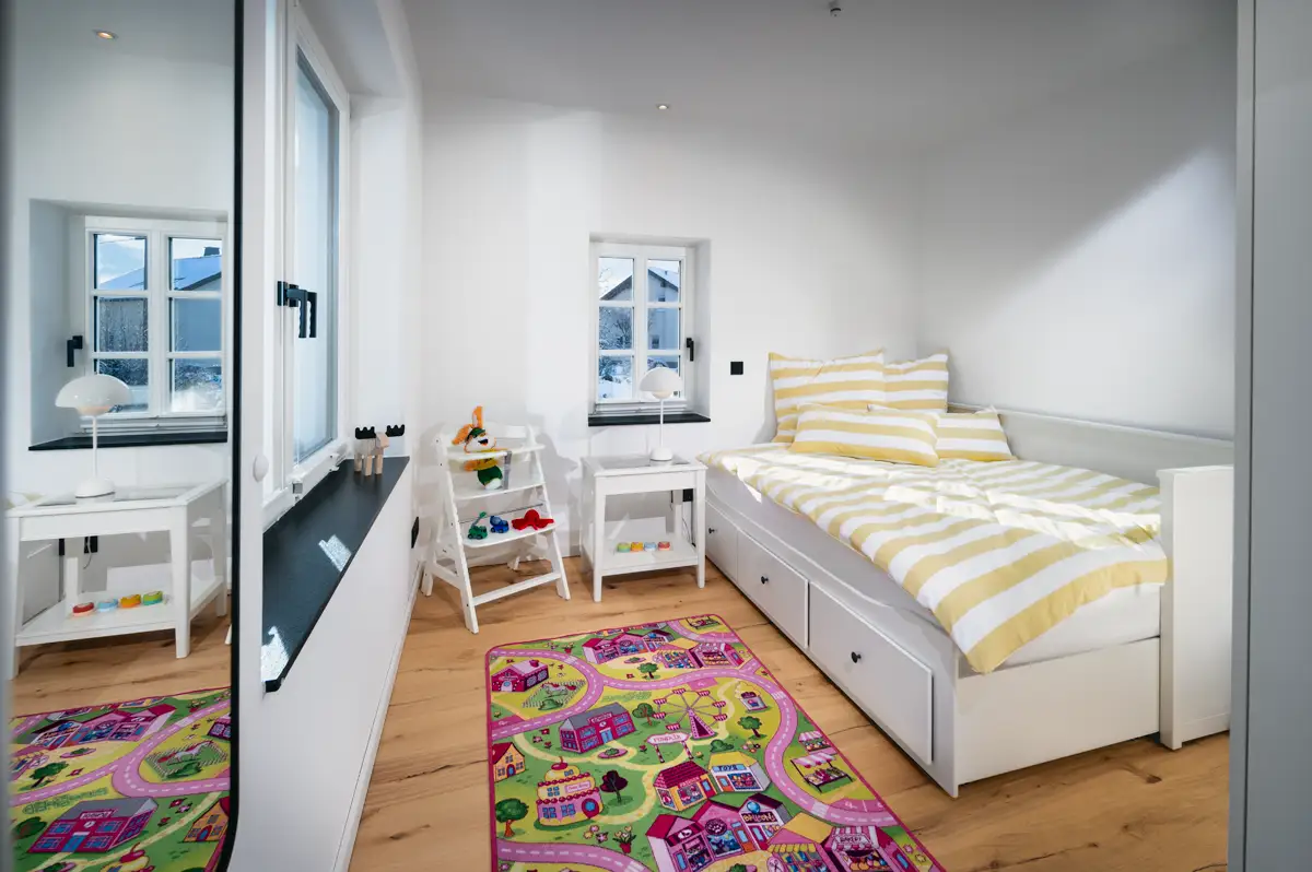 Kindgerecht ausgestattetes Schlafzimmer (3) mit Hochstuhl, Spielteppich und Spielzeugen. Fachwerkhaus Eiben, Ferienwohnung in Kirchhundem-Benolpe